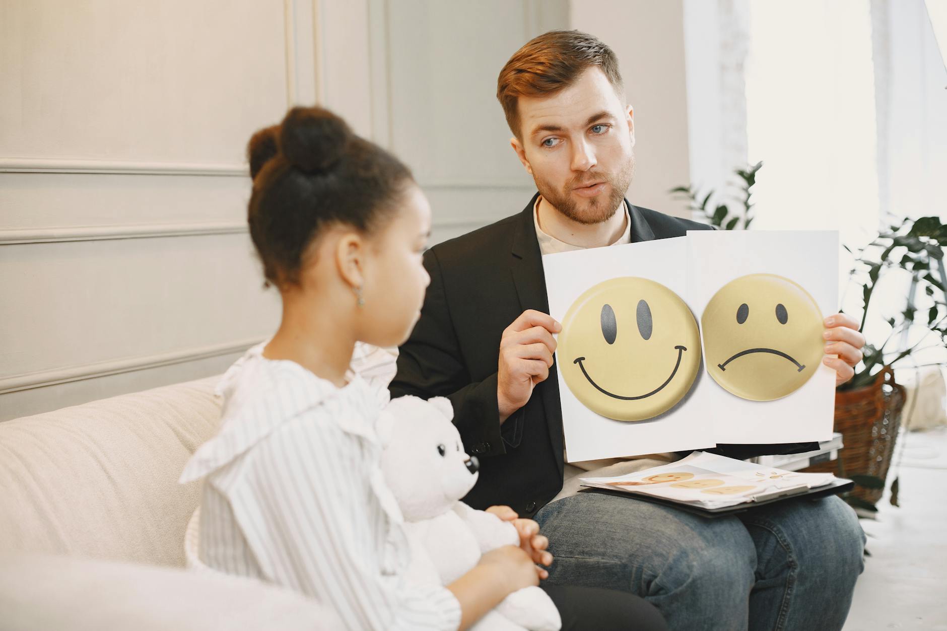 Logopeda z dzieckiem używają kart emocji podczas zajęć