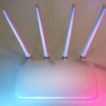 Nowoczesny biały router Wi-Fi z czterema antenami w niebiesko-różowym świetle