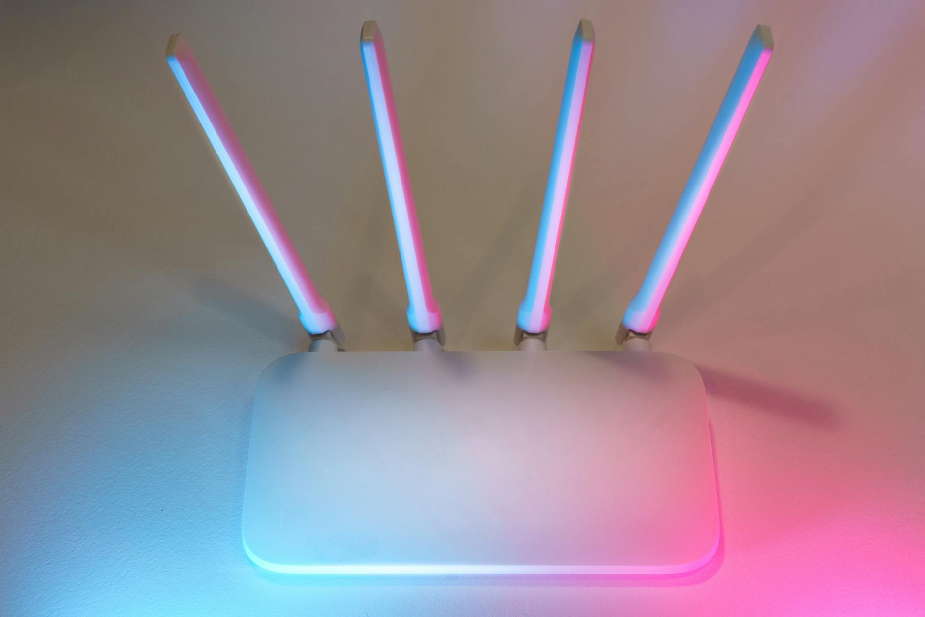 Nowoczesny biały router Wi-Fi z czterema antenami w niebiesko-różowym świetle